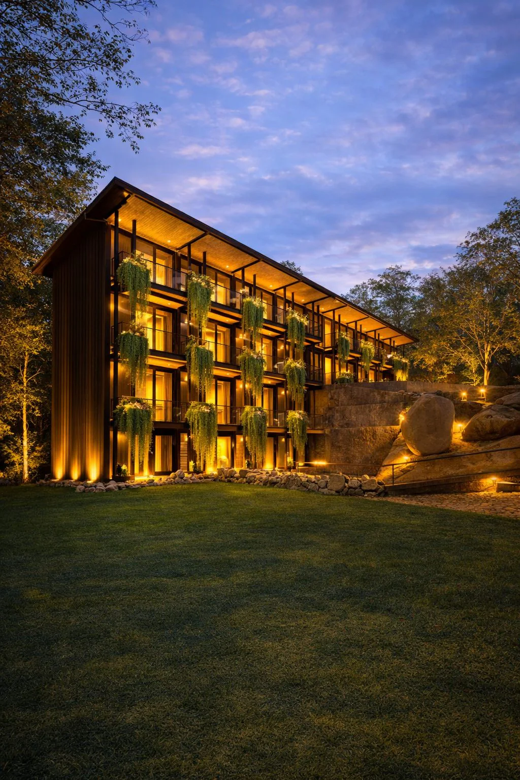 Area 83 boutique hotel, Karnataka — stacked timber rooms lit at dusk